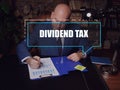 DIVIDEND TAX text in footnote block. Bookkeeping clerk checking financial report AÃÂ dividend taxÃÂ is aÃÂ taxÃÂ imposed by a